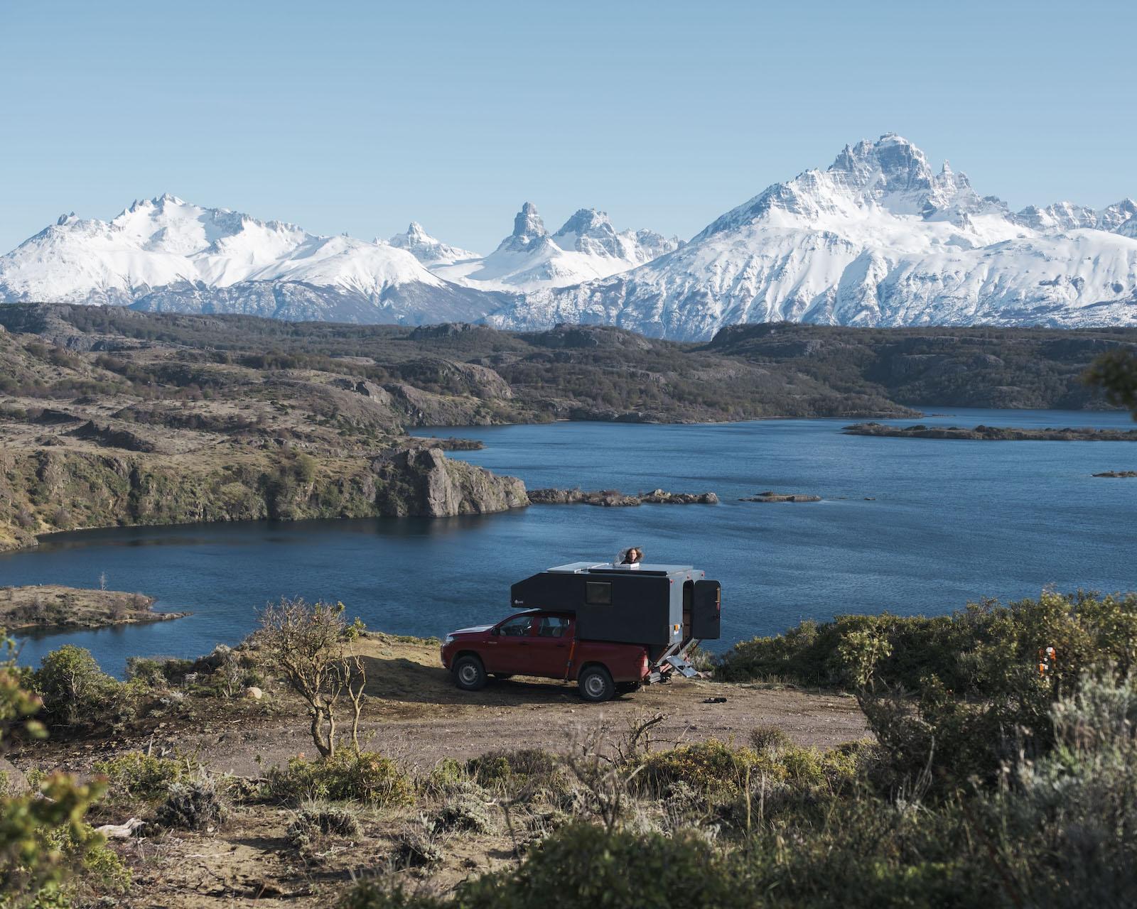 Nomad Camper parked above a lake in Aysén, Chilean Patagonia, with Cerro Castillo behind